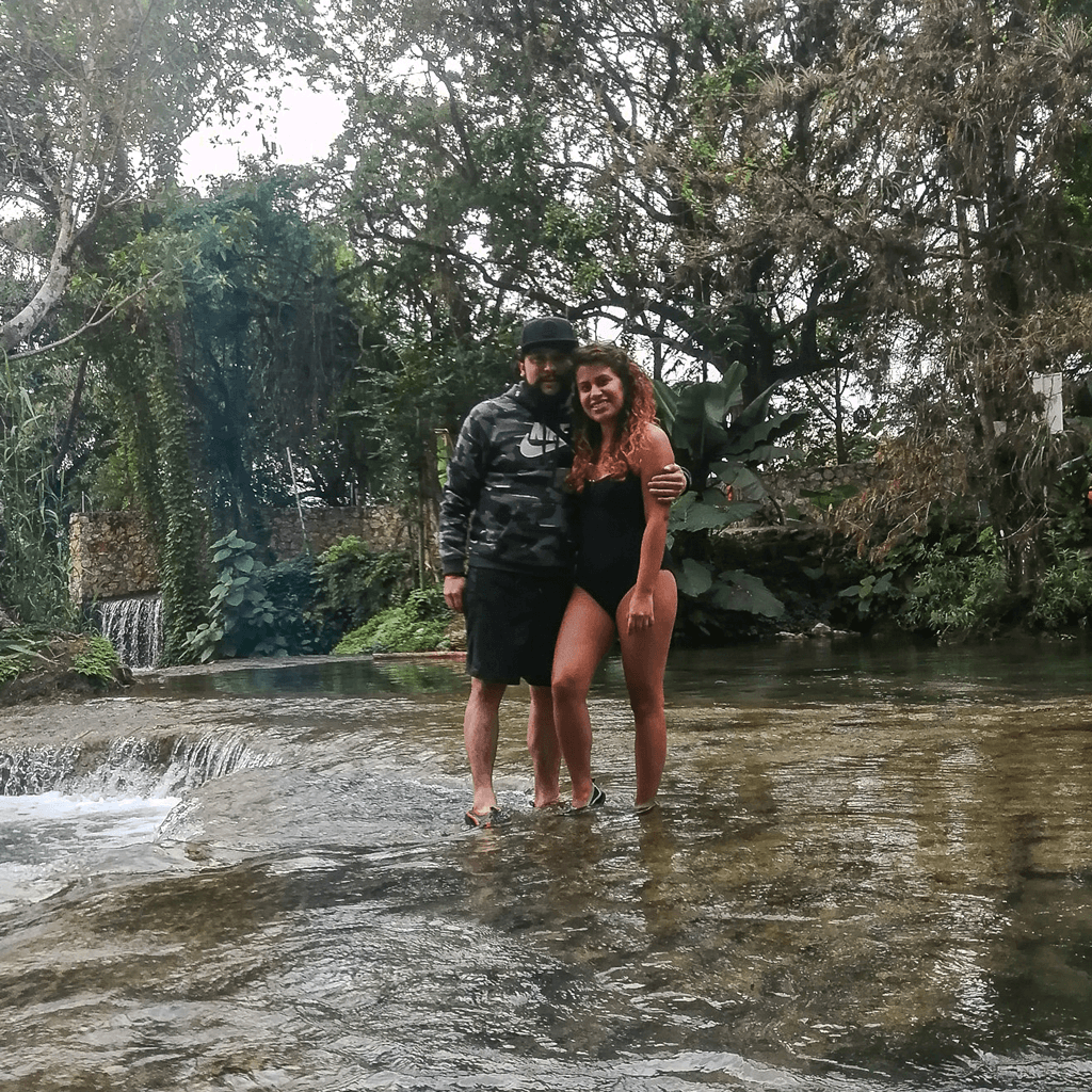 Danni y Mike abrazados en un río entre la naturaleza