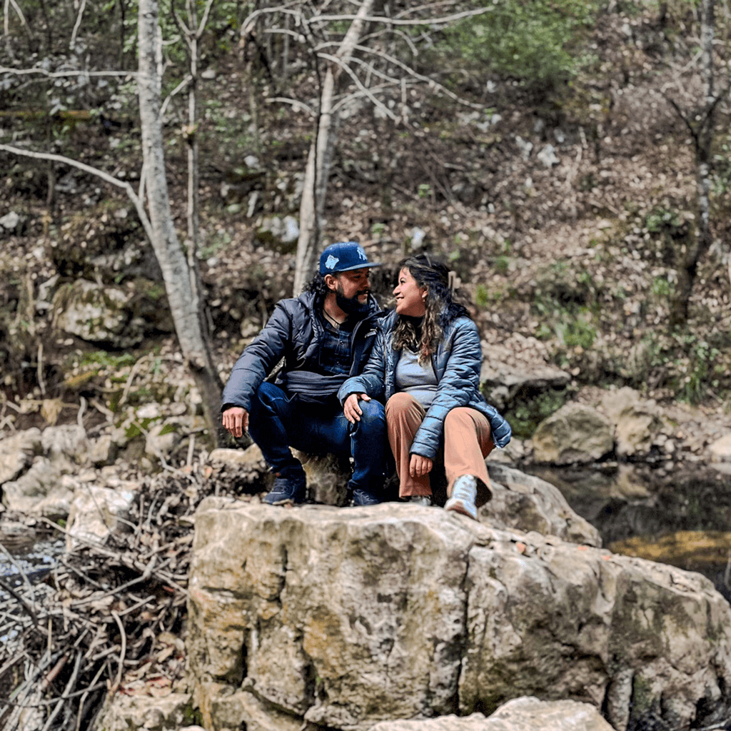 Danni y Mike sentados en una roca durante una caminata